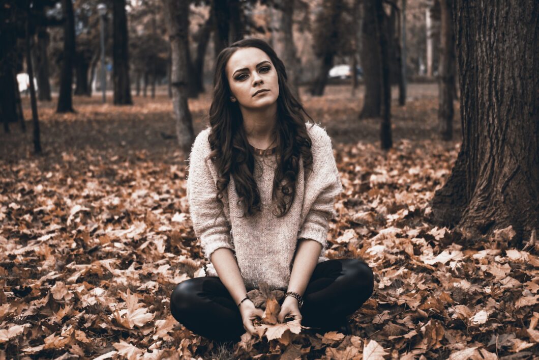 une femme assise dans la forêt exprime de la tristesse et de la souffrance