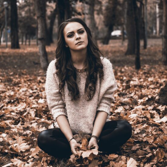 une femme assise dans la forêt exprime de la tristesse et de la souffrance
