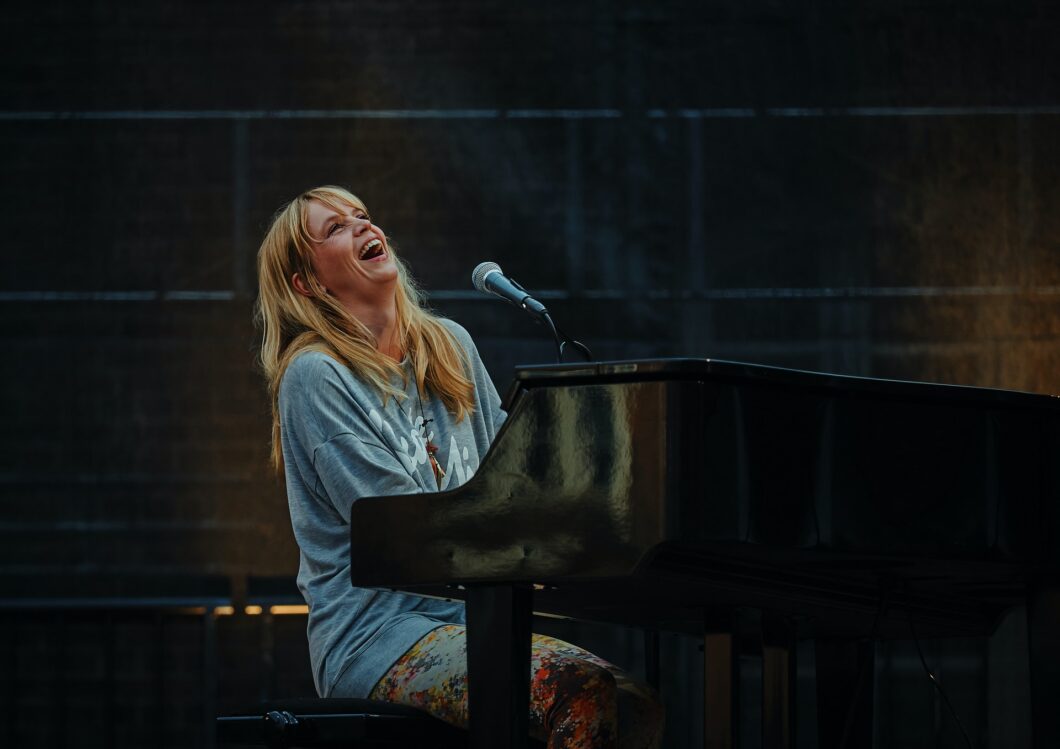 une femme chante d'une voix forte et aigue et joue du piano